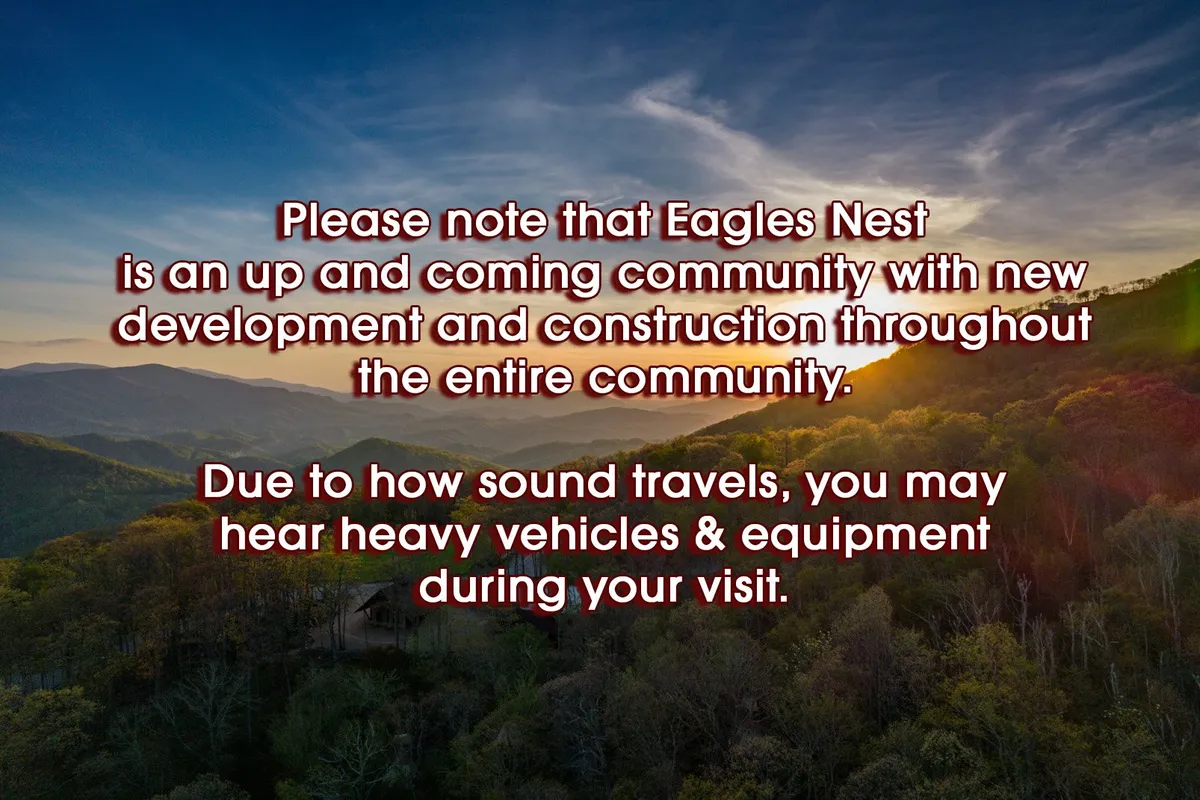 A panoramic view of a mountainous landscape at sunset, with a construction sign visible in the foreground. The scene is open and expansive, highlighting the natural beauty and adventure opportunities around Eagles Nest. The presence of construction signage hints at ongoing development in the community.
