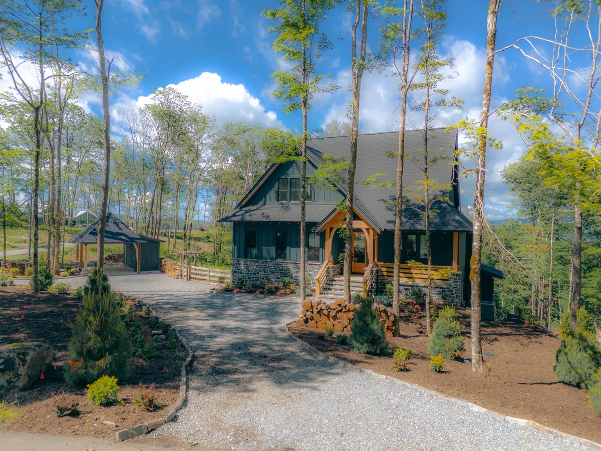 This image shows the front porch of the lodge, with the house, driveway, and landscaped garden in view. The welcoming scene captures the approach to the home, surrounded by greenery and open space—ideal for walks and pet-friendly adventures right outside the door.